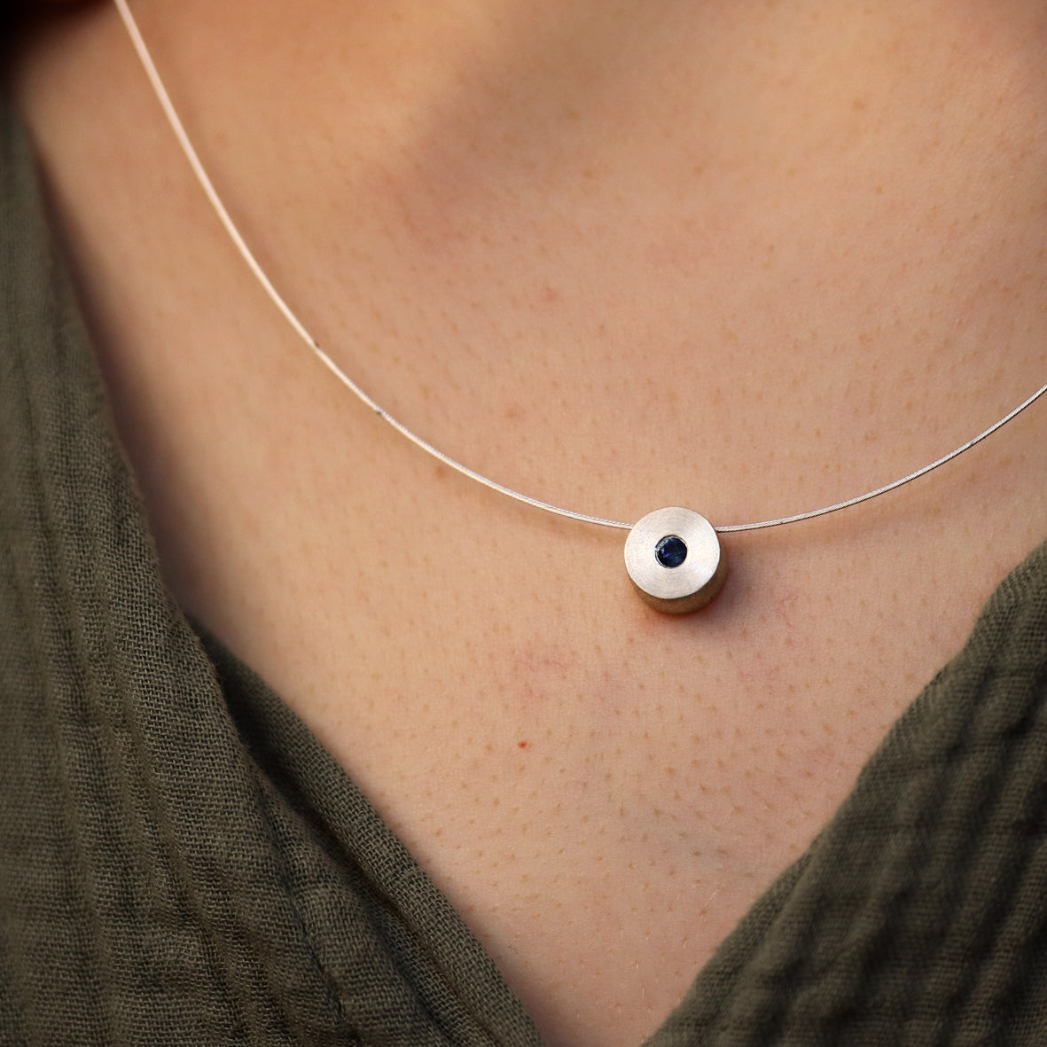 Silberscheibe mit kleinem Saphir